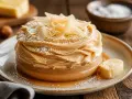 Gâteau crémeux avec chantilly chocolat blanc, garni de copeaux dorés et saupoudré de sucre glace. Un délice visuel et gustatif.