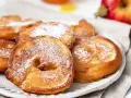 Délicieux beignets aux pommes saupoudrés de sucre glace, prêts à être dégustés.