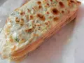 Gozleme épinard, une crêpe turque dorée et pliée, garnie d'épinards frais et savoureux.