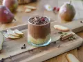 Délicieuse recette mousse poire chocolat, garnie de copeaux de chocolat et d'une framboise. Poires fraîches et épices sur fond de bois.