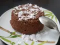 Un délicieux bowl cake au chocolat, saupoudré de sucre glace, prêt à être dégusté avec une cuillère.