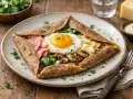 Une galette garnie d'un œuf au plat, de jambon, de champignons et d'épinards. Un délice de crêpes salées !