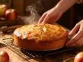 Un délicieux quatre-quarts fumant, tout juste sorti du four, avec des pommes en arrière-plan.