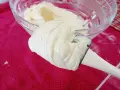 Crème onctueuse de mascarpone sur une spatule, prête pour une délicieuse recette.