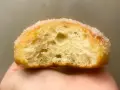 Gros plan d'un beignet sucré, sa mie aérée parfaite pour une recette beignet maison.
