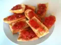 Des tranches de pain grillé garnies de tomates fraîches et d'herbes. Un délice simple et savoureux, parfait pour un apéritif.