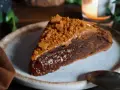 Une part de gâteau speculoos, riche et gourmande, garnie de miettes de biscuits et d'une sauce caramel.