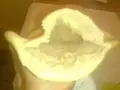 Une main tient un pain libanais ouvert, prêt à être garni. Sa texture moelleuse et sa poche invitent à la gourmandise.