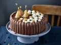 Charlotte poire chocolat, un gâteau élégant avec des poires pochées dorées, de la crème fouettée et des éclats de chocolat.