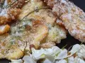 Délicieux beignets d'acacia, croustillants et saupoudrés de sucre, accompagnés de fleurs blanches.