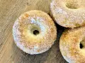 Trois donuts dorés, saupoudrés de sucre, prêts à être dégustés. Une recette donuts simple et gourmande.