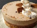 Gâteau à la mousse légère, décoré de crème fouettée, de pépites de chocolat et de biscuits speculoos croustillants.
