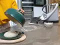 Préparation de la pâte à pizza avec un robot culinaire. Une boule de pâte repose sur un plat vert, prête à être cuite.