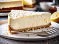 Tranche de cheesecake sans cuisson crémeux, garnie de miettes et de sucre glace, avec un quartier de citron à côté.