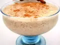 Un déliceux mousse banane crémeuse, saupoudrée de cannelle, servie dans un joli bol en verre bleu.