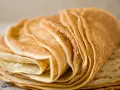Pile de crêpes dorées, parfaites pour une recette crêpe sans beurre. Elles sont fines et légères, prêtes à être garnies.