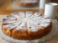 Gâteau mascarpone saupoudré de sucre glace, prêt à être dégusté avec une tasse de café.