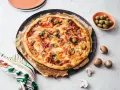 Une délicieuse pizza reine, garnie de jambon, champignons et olives, prête à être dégustée.