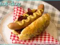 Un hot-dog gourmand avec un pain aux graines de pavot, garni de saucisse, oignons caramélisés et moutarde. Parfait pour une recette pain hot dog facile.