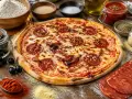 Pizza chorizo appétissante, garnie de rondelles de chorizo croustillantes, entourée d'ingrédients frais pour une création parfaite.