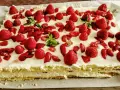 Un délicieux entremet fraise, garni de fruits rouges frais et de feuilles de menthe, sur une base crémeuse.
