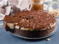 Gâteau façon Snickers, avec une base chocolatée, une couche crémeuse, du caramel coulant et une ganache au chocolat parsemée de cacahuètes. Un délice !