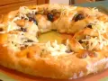 Pizza maison avec une croûte dorée, garnie d'olives noires et de fromage râpé. Parfait pour une recette pâte à pizza rapide.