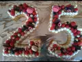 Gâteau chiffre 25 décoré de chantilly mascarpone, framboises, fraises, myrtilles, macarons et chocolat.