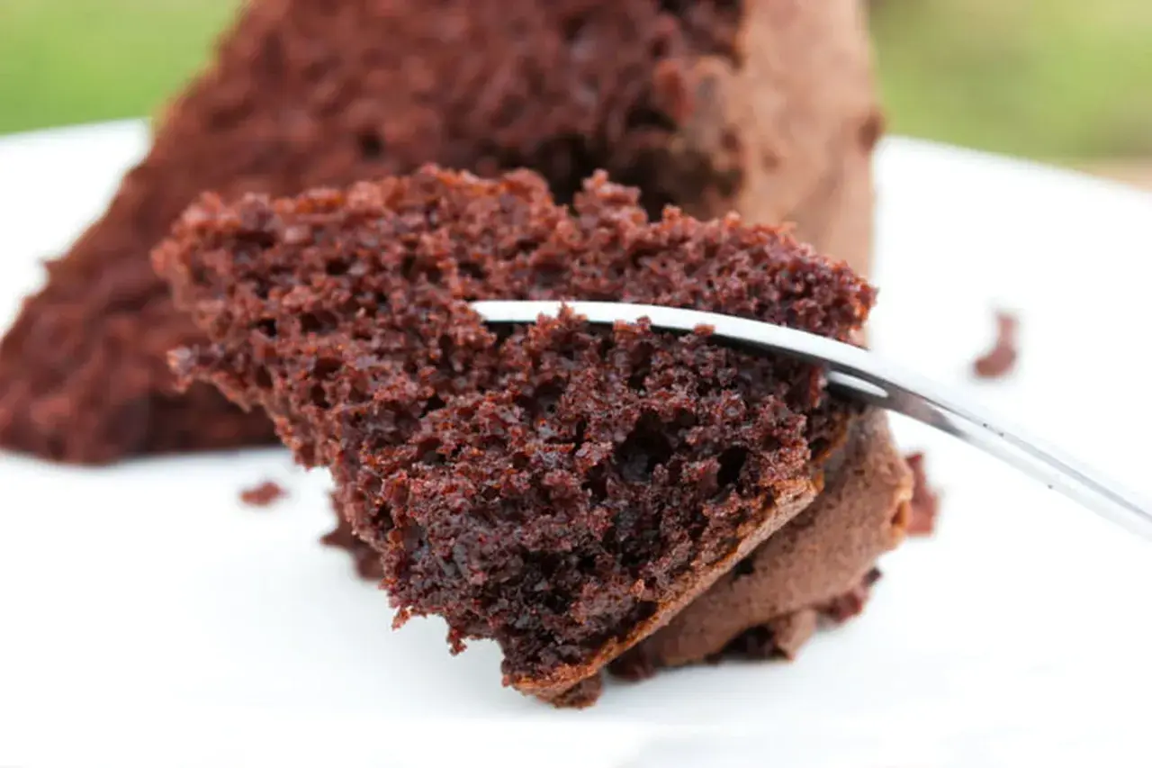 Une part de moelleux au chocolat, aérienne et gourmande, est coupée par une fourchette.