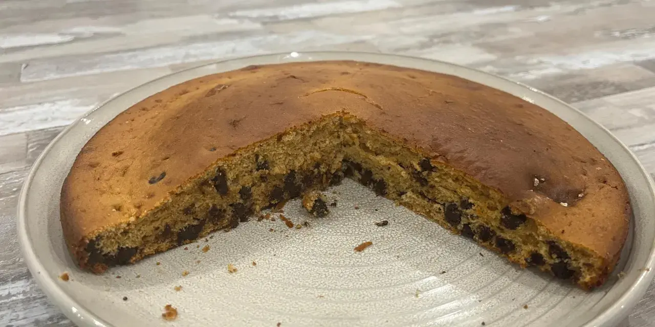 Gâteau chocolat compote, moelleux et parsemé de pépites, prêt à être dégusté.