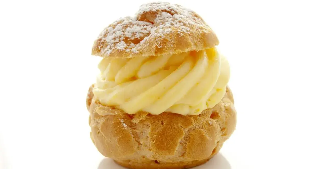 Un déliceux chou à la crème, saupoudré de sucre glace, avec une généreuse garniture de crème pâtissière onctueuse.