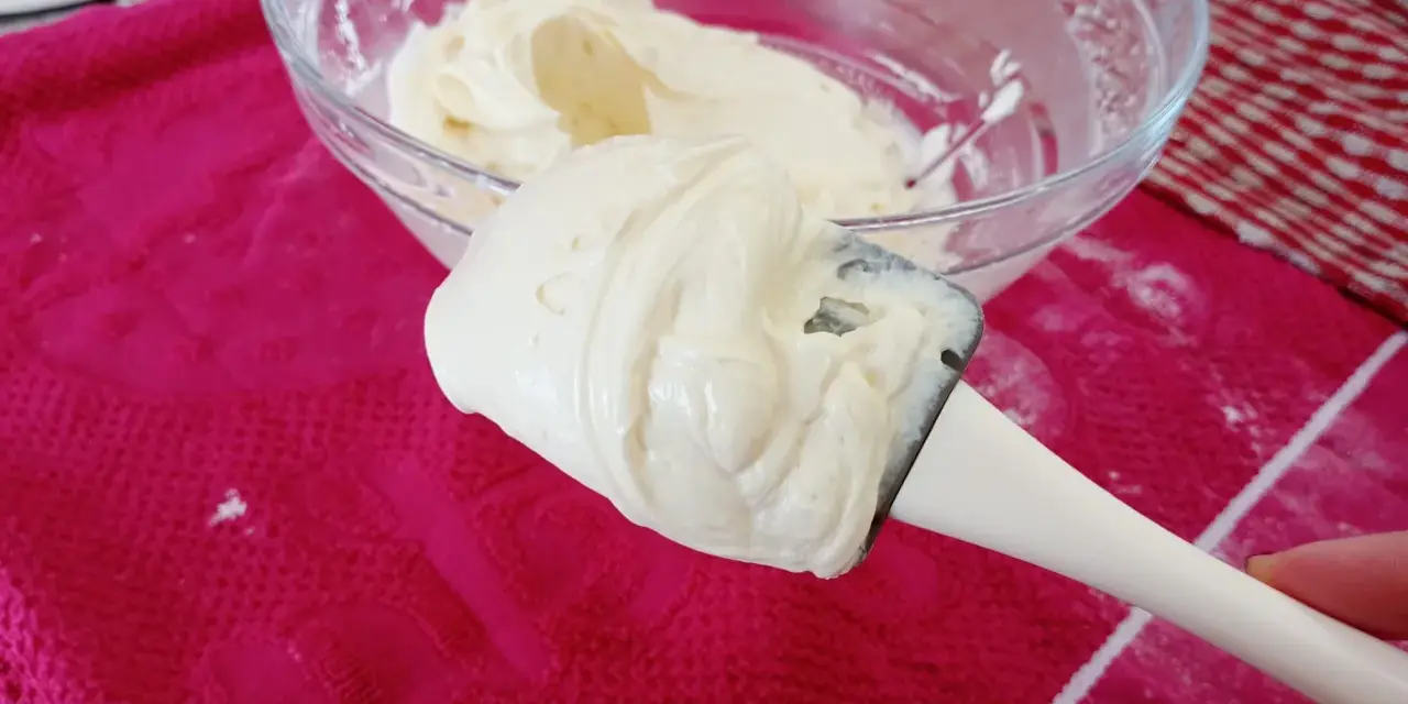 Crème onctueuse de mascarpone sur une spatule, prête pour une délicieuse recette.