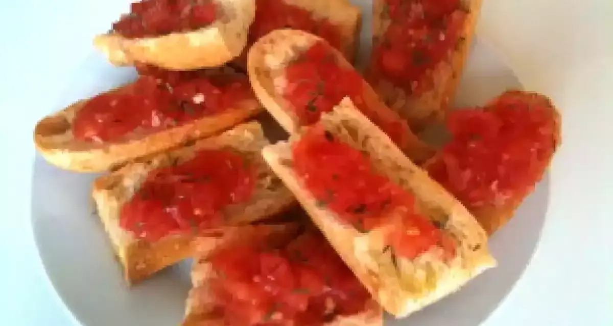 Des tranches de pain grillé garnies de tomates fraîches et d'herbes. Un délice simple et savoureux, parfait pour un apéritif.
