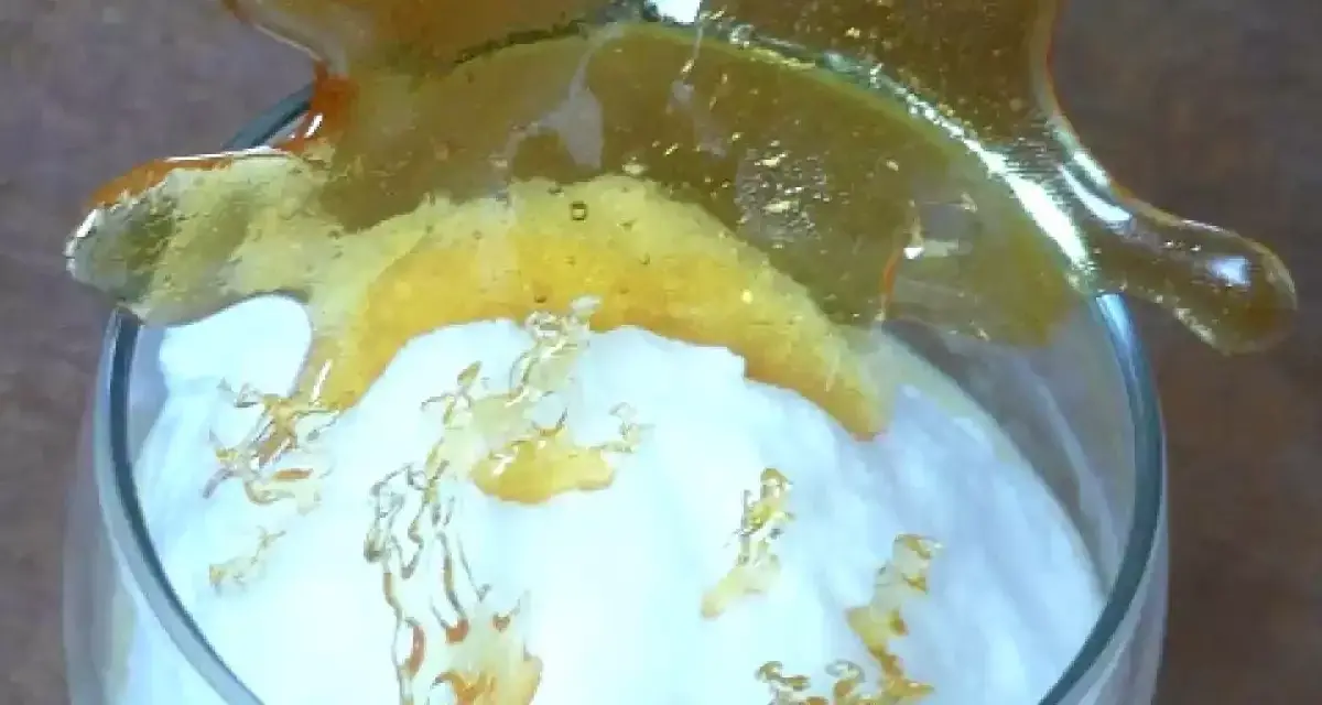 Un verre de crème aérienne surmonté d'une décoration en caramel craquant. Ces oeufs à la neige sont prêts à être dégustés.