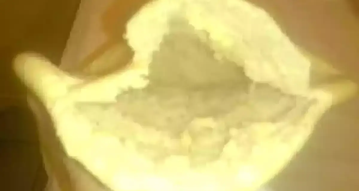 Une main tient un pain libanais ouvert, prêt à être garni. Sa texture moelleuse et sa poche invitent à la gourmandise.