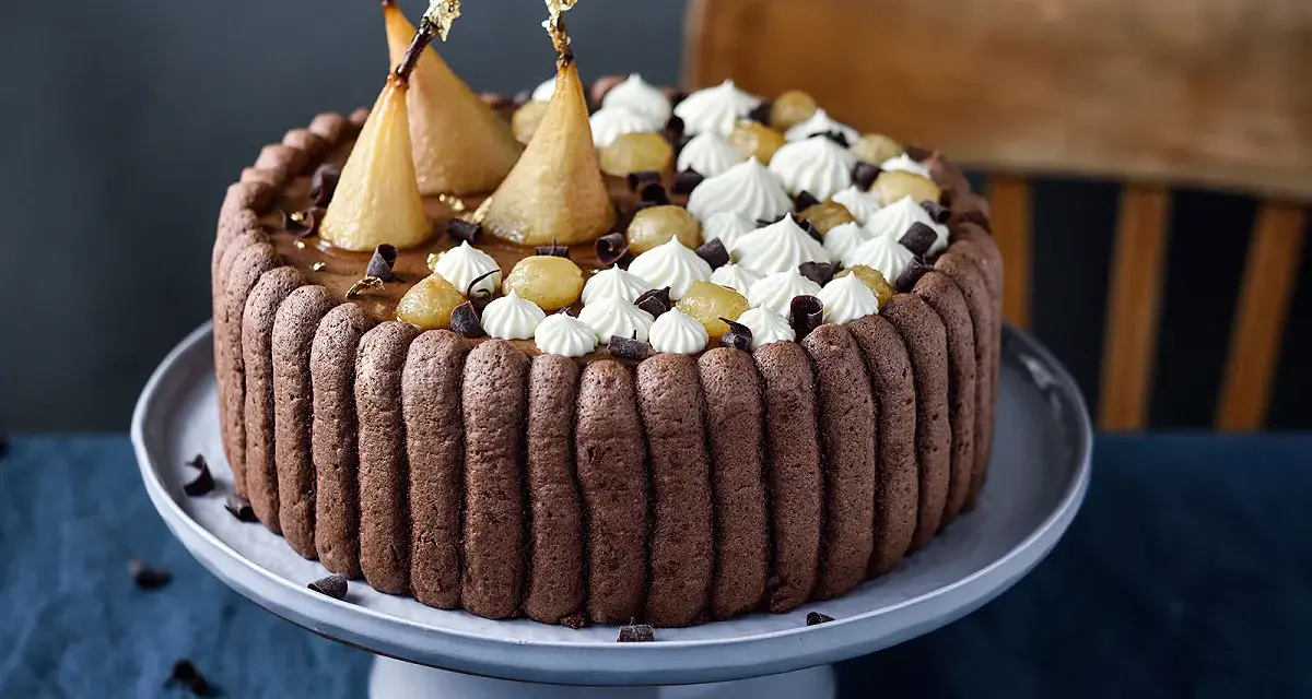 Charlotte poire chocolat, un gâteau élégant avec des poires pochées dorées, de la crème fouettée et des éclats de chocolat.