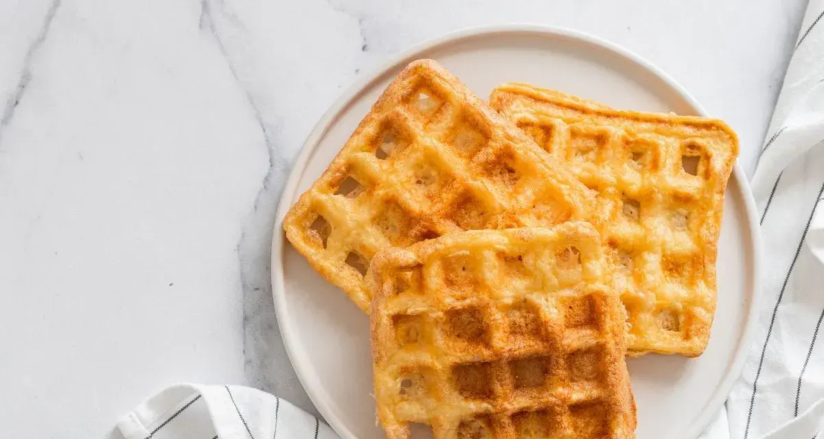 Trois gaufres au sarrasin dorées et croustillantes sur une assiette blanche, prêtes à être dégustées.