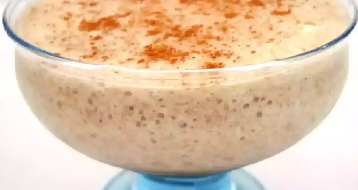 Un déliceux mousse banane crémeuse, saupoudrée de cannelle, servie dans un joli bol en verre bleu.