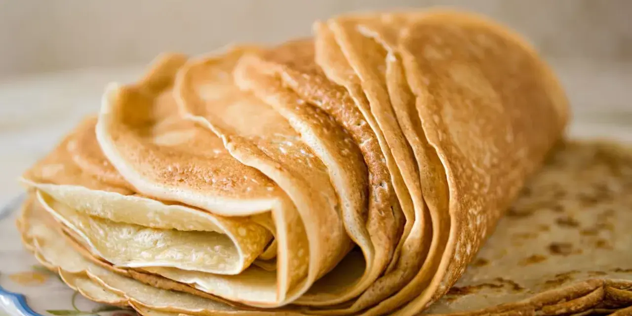 Pile de crêpes dorées, parfaites pour une recette crêpe sans beurre. Elles sont fines et légères, prêtes à être garnies.