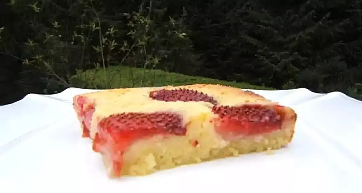 Un délicieux clafoutis aux fraises, tout juste sorti du four, sur une assiette blanche.