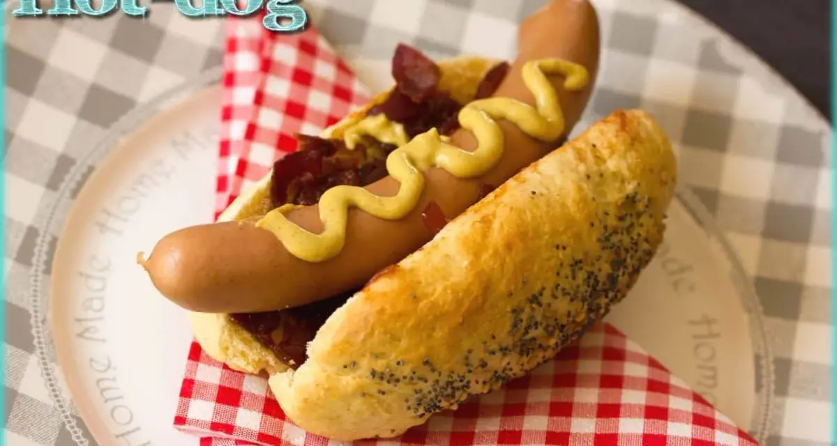 Un hot-dog gourmand avec un pain aux graines de pavot, garni de saucisse, oignons caramélisés et moutarde. Parfait pour une recette pain hot dog facile.