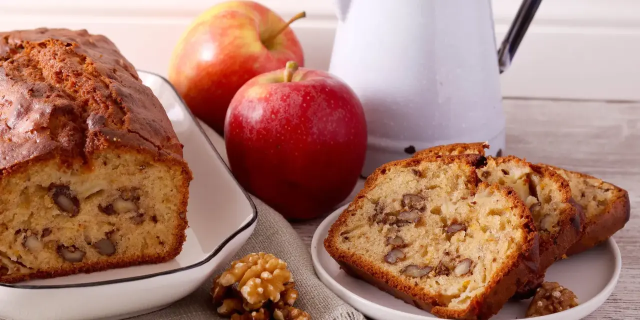 Un délicieux gâteau aux pommes et noix de grand-mère, avec des tranches présentées sur une assiette.