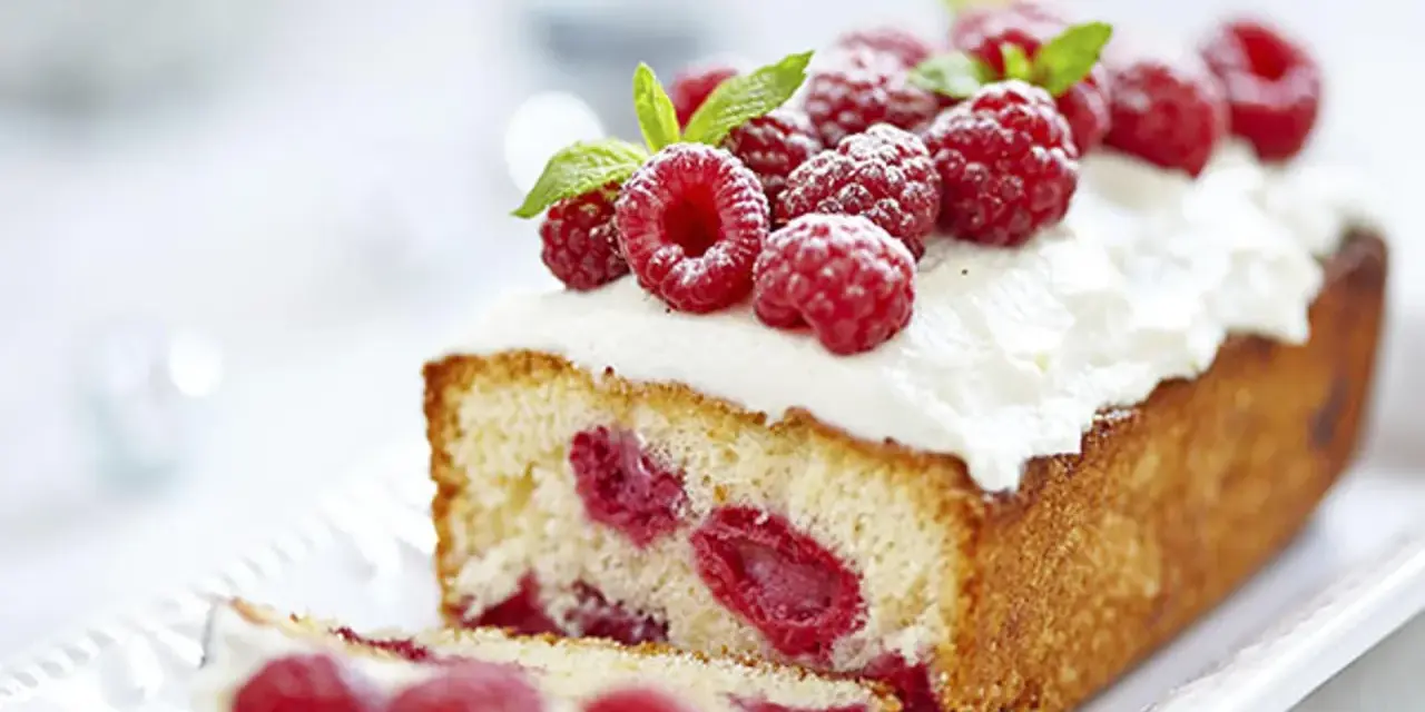 Un délicieux framboisier gateau, garni de framboises fraîches et de crème fouettée, prêt à être dégusté.
