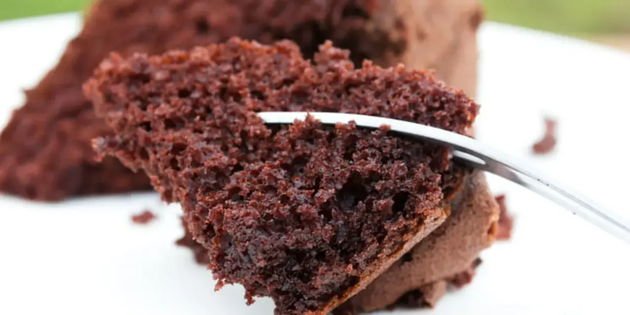 Une part de moelleux au chocolat, aérienne et gourmande, est coupée par une fourchette.