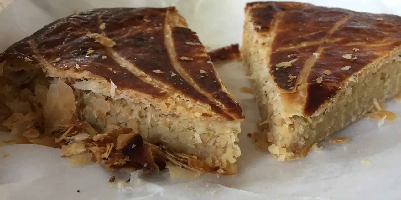 Deux parts de galette des rois coco, avec leur feuilletage doré et leur garniture généreuse, prêtes à être dégustées.