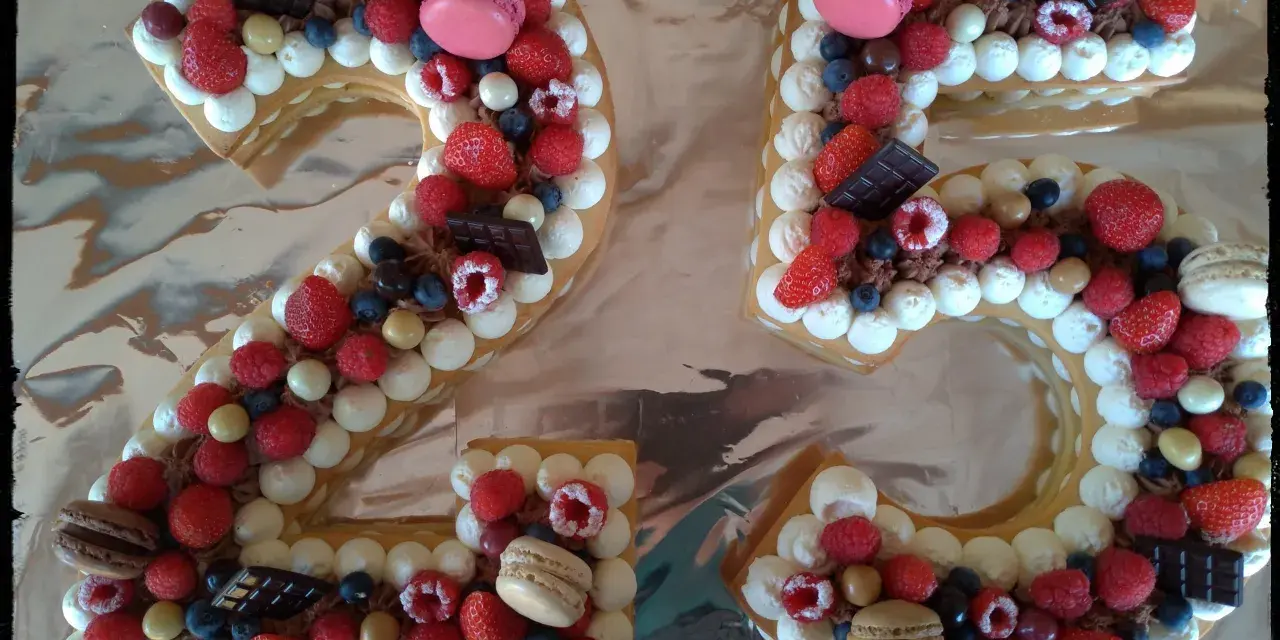 Gâteau chiffre 25 décoré de chantilly mascarpone, framboises, fraises, myrtilles, macarons et chocolat.