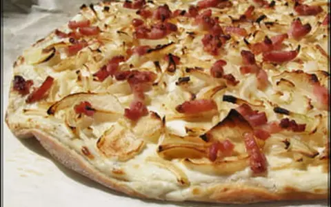Flammekueche croustillante, garnie d'oignons et de lardons. Une recette simple et savoureuse pour un apéritif ou un repas léger.