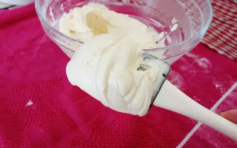 Crème onctueuse de mascarpone sur une spatule, prête pour une délicieuse recette.