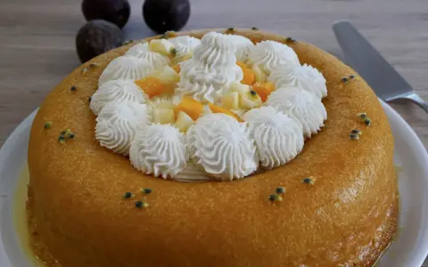 Un baba au rhum doré, garni de crème fouettée, fruits exotiques et graines de fruits de la passion. Un délice !