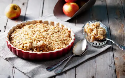 Un délicieux crumble pomme tout juste sorti du four, prêt à être dégusté. Des pommes fondantes sous une couche croustillante.